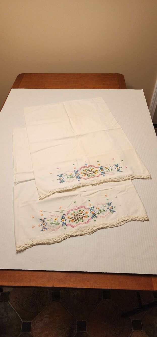Two vintage embroidered pillowcases with crocheted edge and floral design